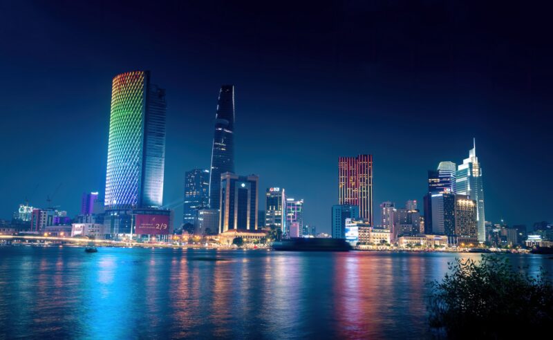 View Of Bitexco And Ifc One Tower, Buildings, Roads And Saigon River In Ho Chi Minh City Laser And Lighting Show Displayed. Travel And Landscape Concept.